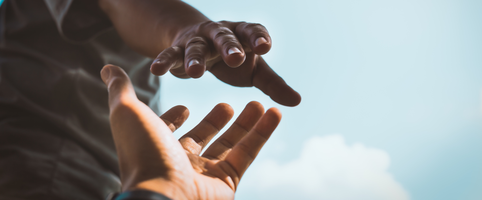 People reaching to one another with their hands.