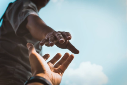 People reaching to hold hands.